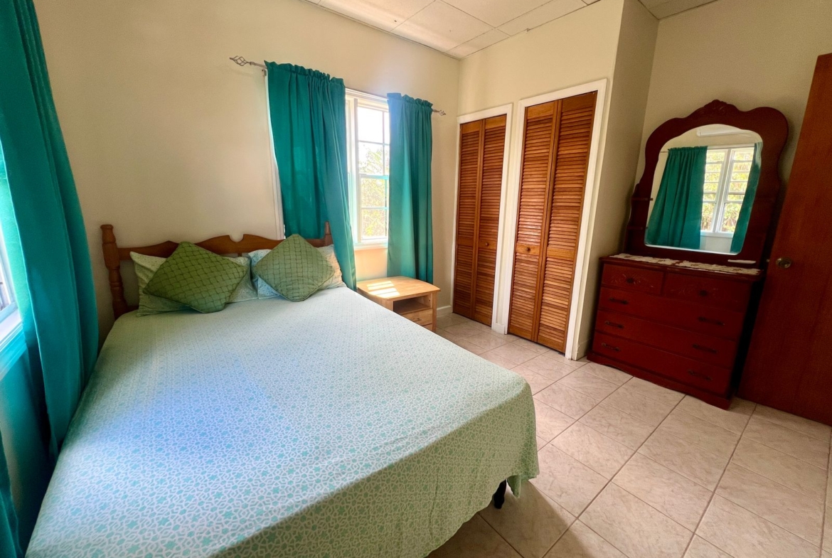 Cozy bedroom with natural light at Emerald Breeze Cottage.
