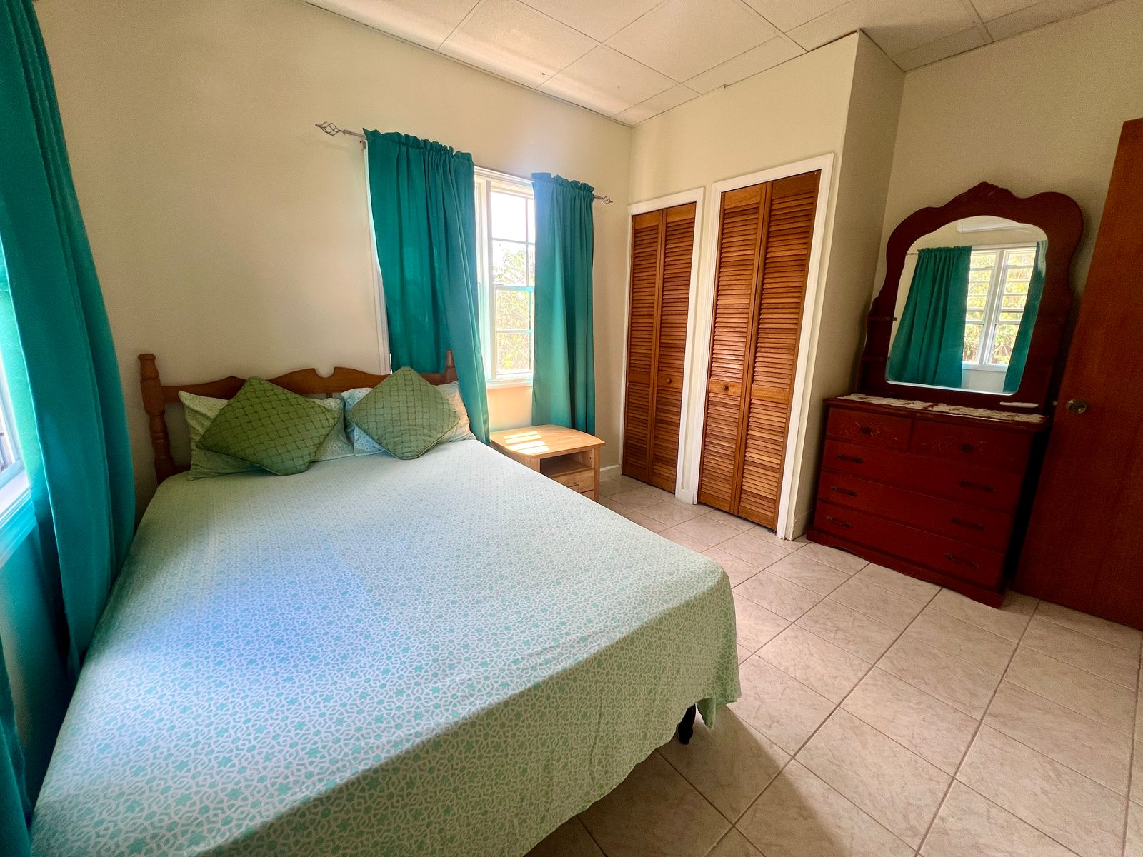Cozy bedroom with natural light at Emerald Breeze Cottage.