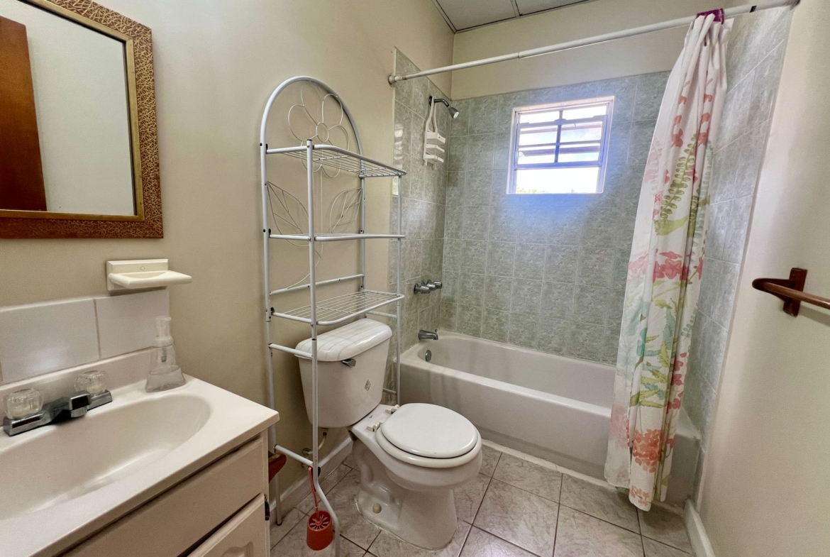Emerald Breeze Cottage surrounded by tropical landscaping.