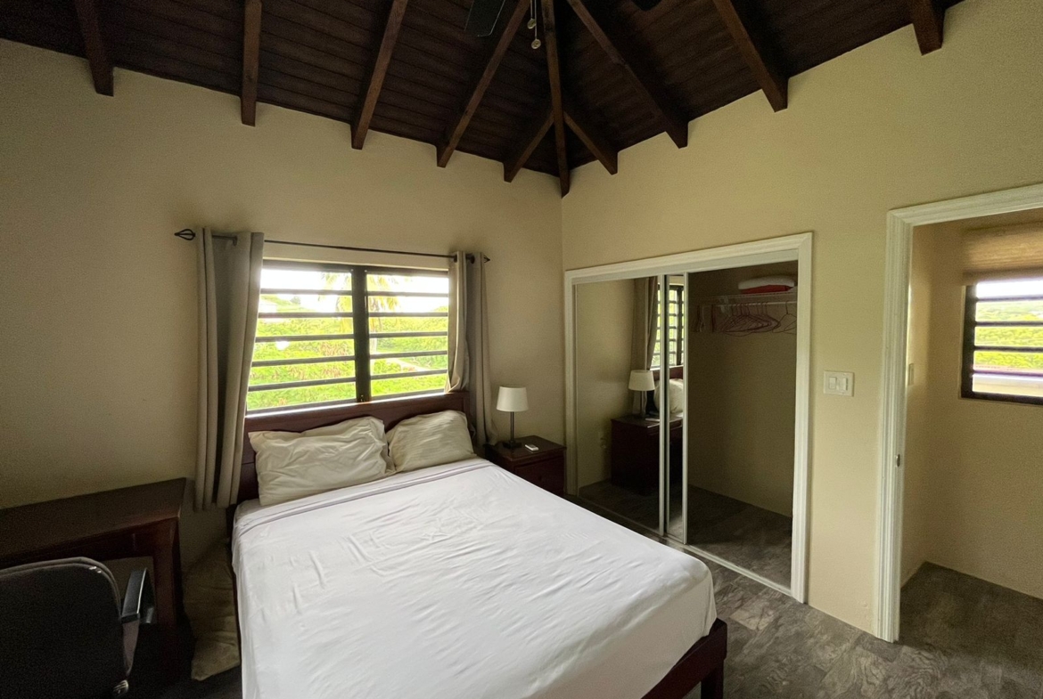 Second bedroom with twin beds and garden view in Antigua apartment