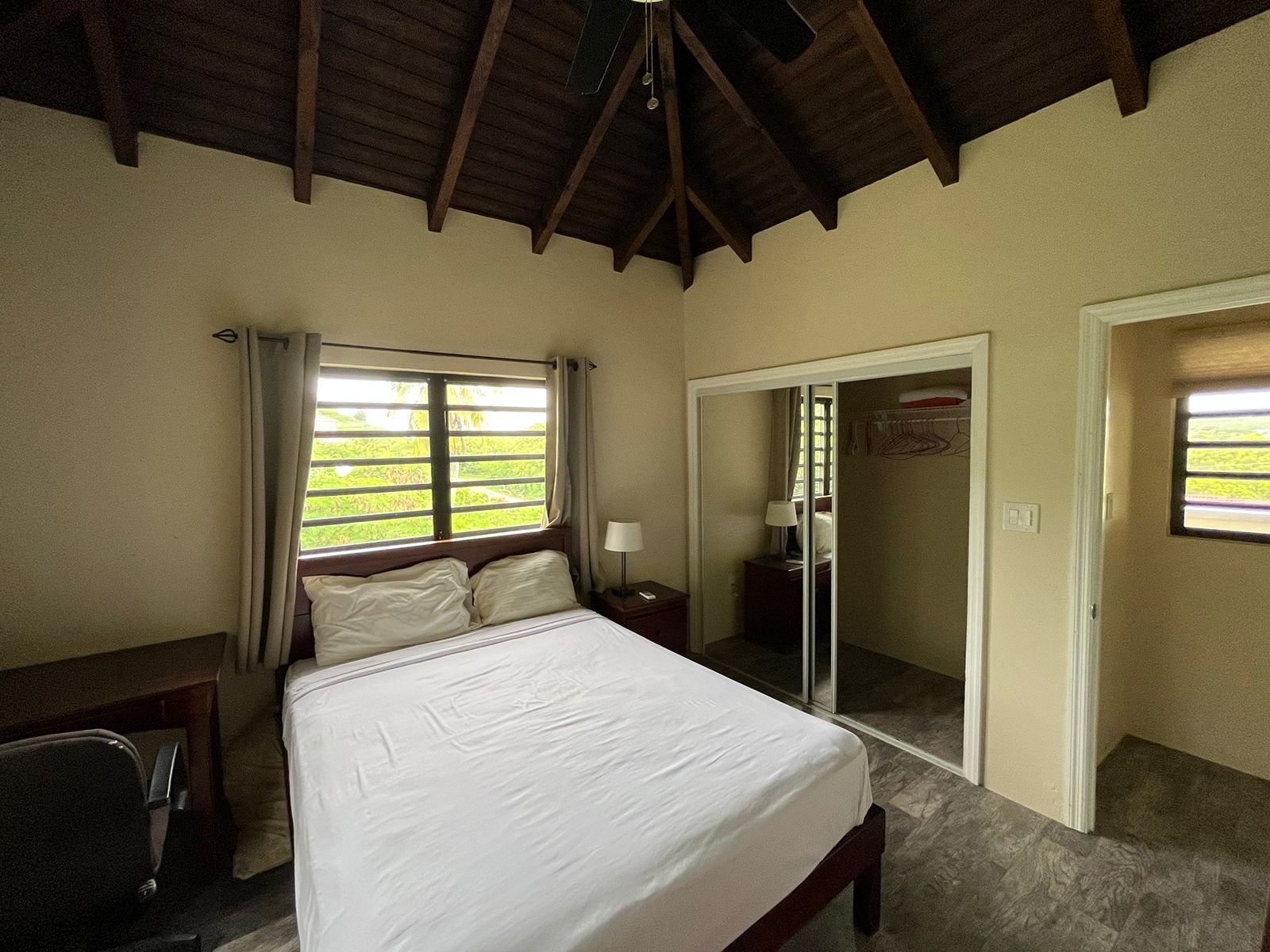 Second bedroom with twin beds and garden view in Antigua apartment